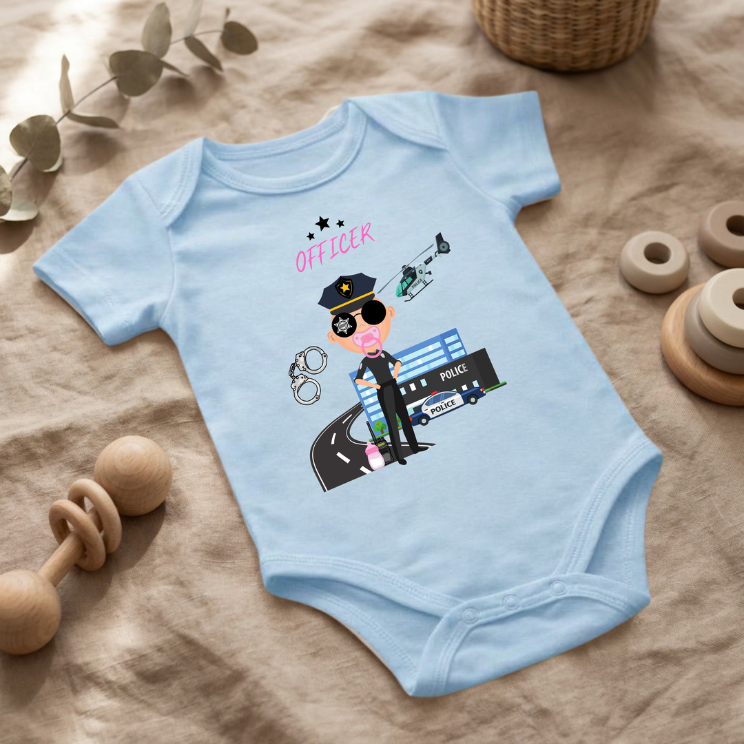 Hellblauer Baby Body für kleine Mädchen mit Polizei- Design im Flat Lay, Baby Kleidung mit Police Officer- Motiv, Geschenkidee für Babys von der Baby und Kleinkind- Brand TIMMY &amp; MIMMY.