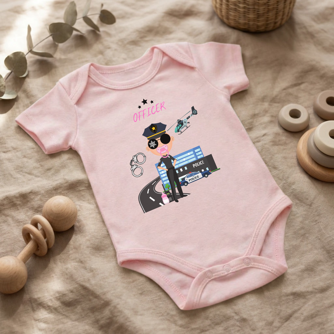 Rosa Baby Body für kleine Mädchen mit Polizei- Design im Flat Lay, Baby Kleidung mit Police Officer- Motiv, Geschenkidee für Babys von der Baby und Kleinkind- Brand TIMMY &amp; MIMMY.