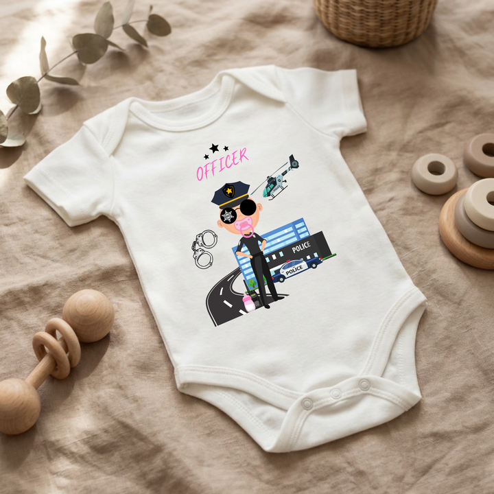 Weißer Baby Body für kleine Mädchen mit Polizei- Design im Flat Lay, Baby Kleidung mit Police Officer- Motiv, Geschenkidee für Babys von der Baby und Kleinkind- Brand TIMMY &amp; MIMMY.