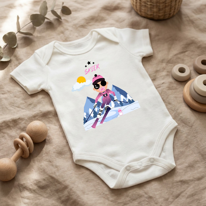 Weißer Baby Body für kleine Mädchen mit Skier- Design im Flat Lay, Baby Kleidung mit Ski- Motiv, Geschenkidee für Babys von der Baby und Kleinkind- Brand TIMMY &amp; MIMMY.