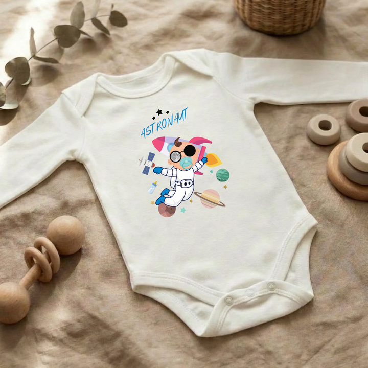 Weißer Baby Body langarm für Jungs im Flat Lay mit Astronaut Design, Baby Kleidung für Herbst und Winter mit Weltraum- und Sternen Look von TIMMY &amp; MIMMY