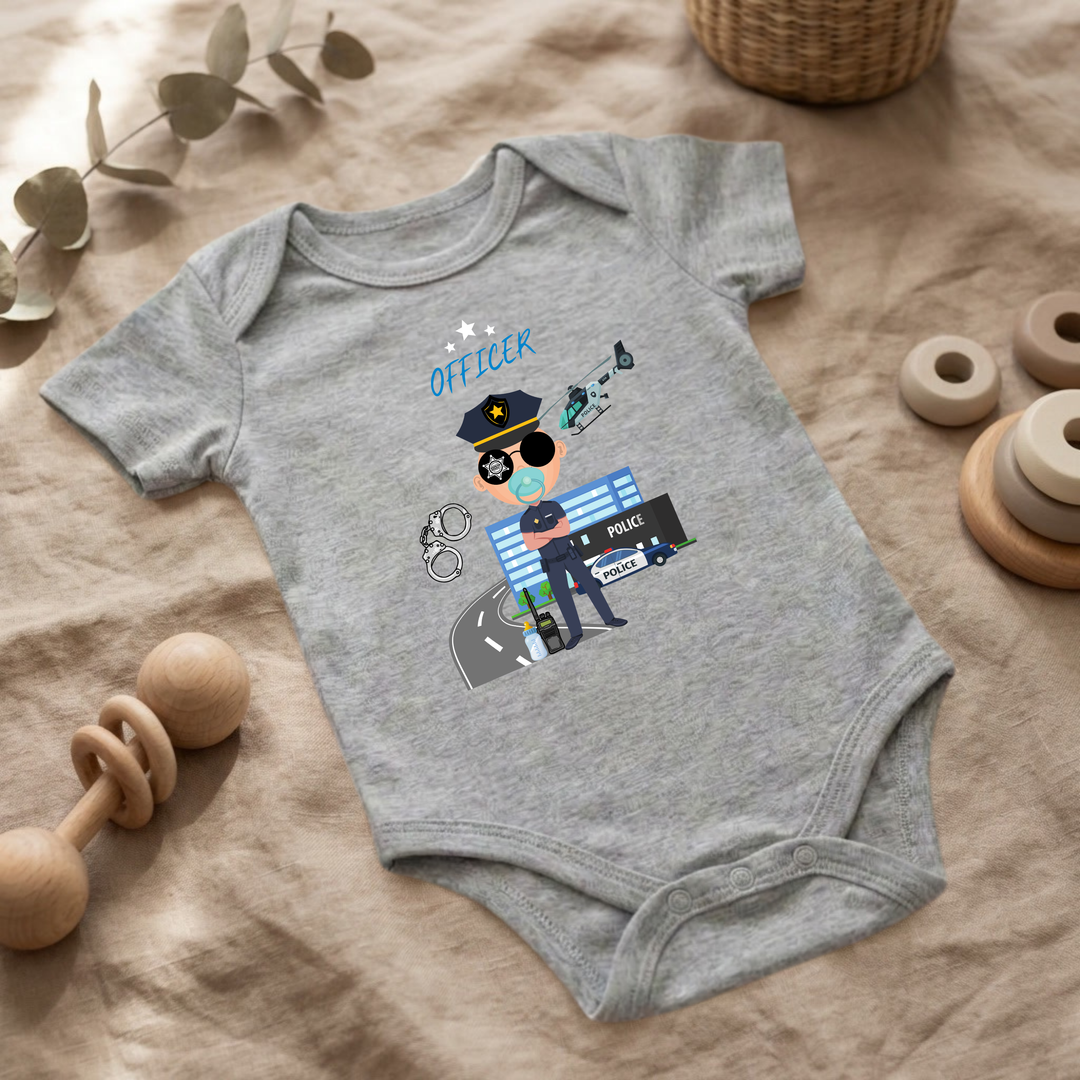 Hellgrauer Baby Body für Jungs mit Polizei- Design im Flat Lay, Baby Kleidung mit Police- Officer- Motiv, Geschenkidee für Babys von der Baby und Kleinkind- Brand TIMMY &amp; MIMMY
