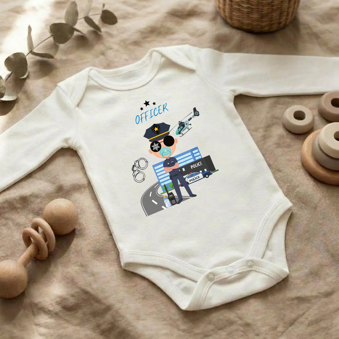 Weißer Baby Body langarm für Jungs im Flat Lay mit Polizei- Design, Baby Kleidung für Herbst und Winter mit Police Officer- Motiv von TIMMY &amp; MIMMY
